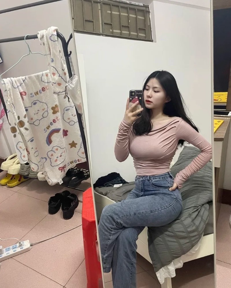 nàng soi gương trong phòng với váy đen bó sát