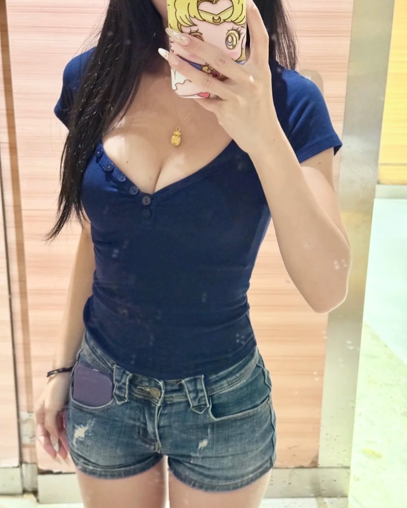 cô gái mặc áo xanh đậm và quần short jean