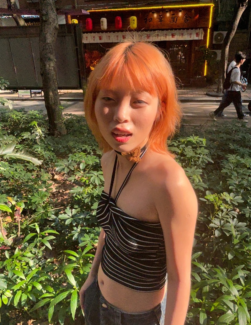 ảnh gái nhuộm tóc cam tạo dáng ngoài trời