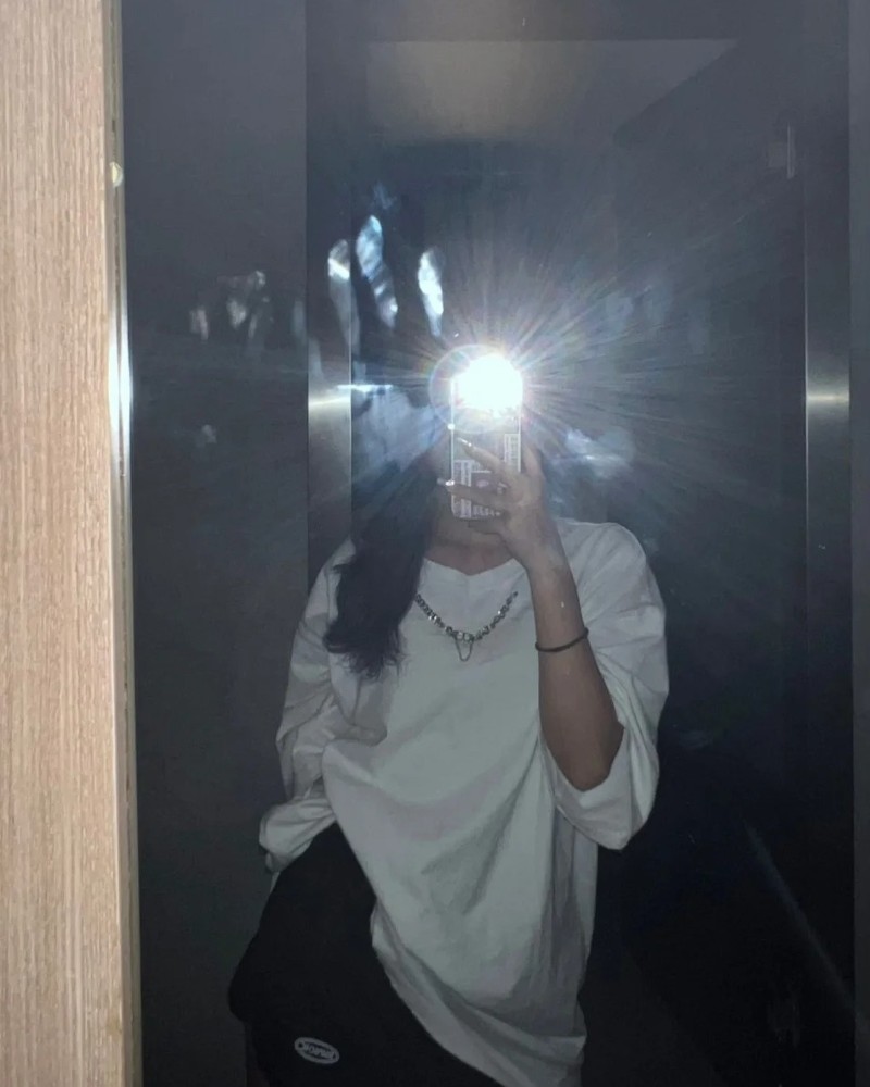 Ảnh cô gái đứng trong ánh đèn chụp gương giấu mặt