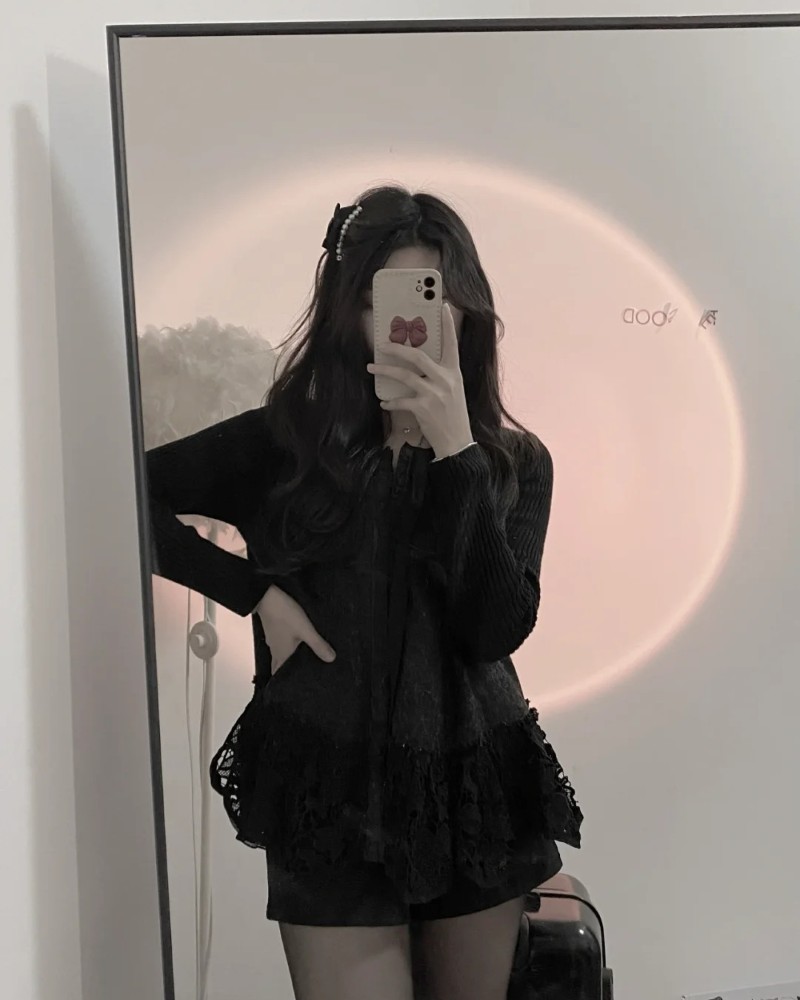 Tạo dáng với bóng đèn phía sau và điện thoại che mặt