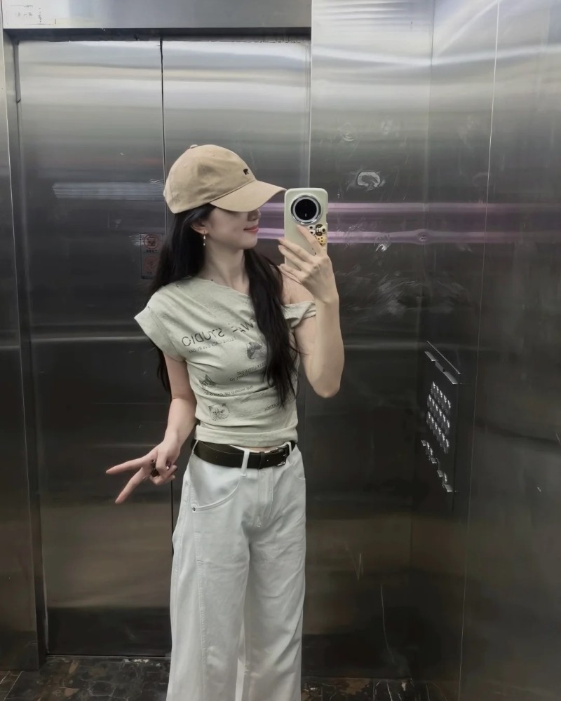 Cô gái diện đồ trắng dùng điện thoại che mặt