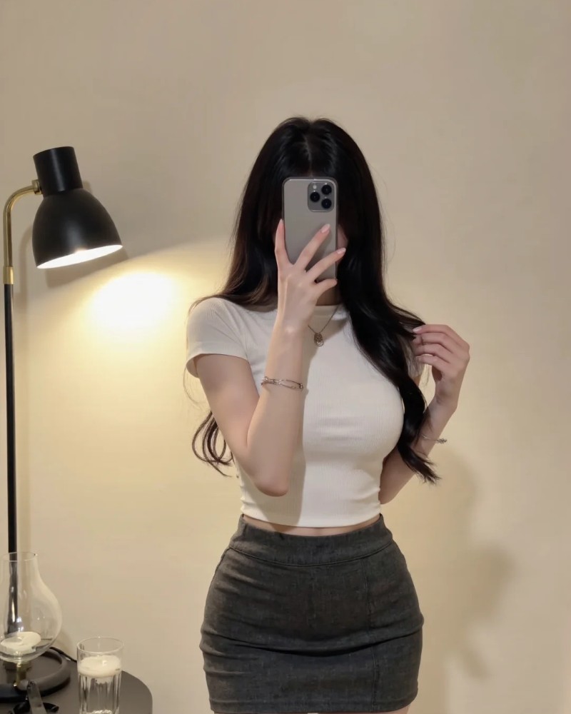 Cô gái mặc áo ôm dùng điện thoại che mặt