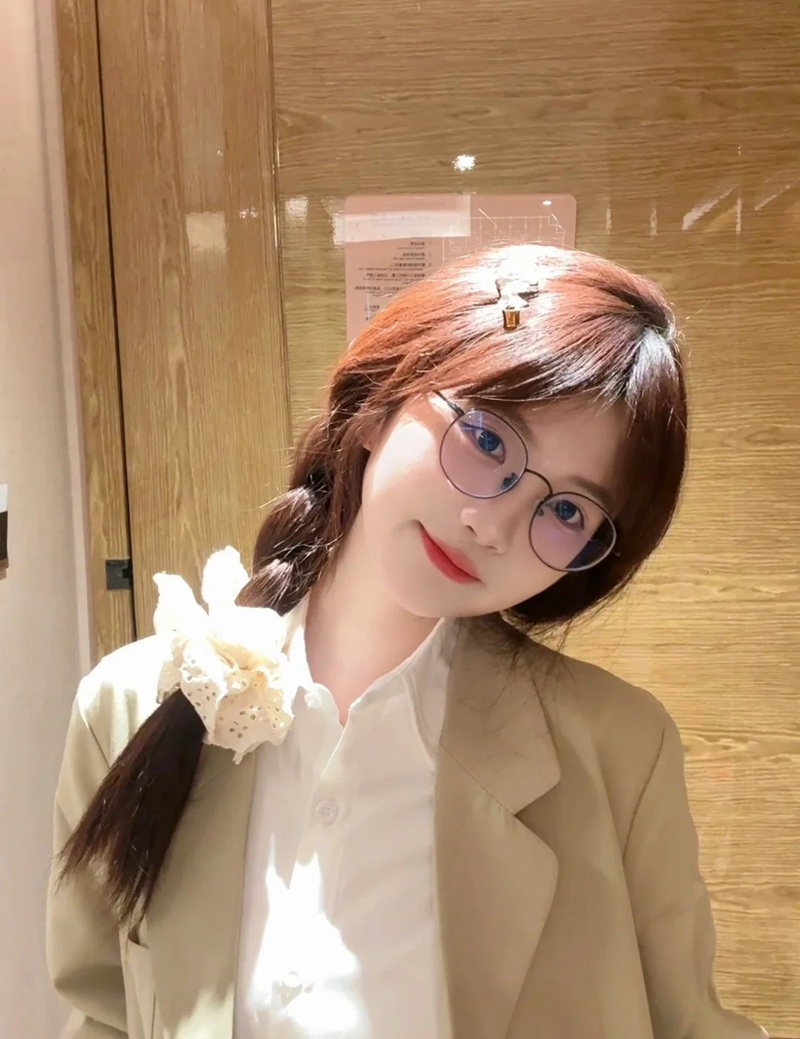 Cô gái đeo kính tạo dáng trước gương phòng tắm