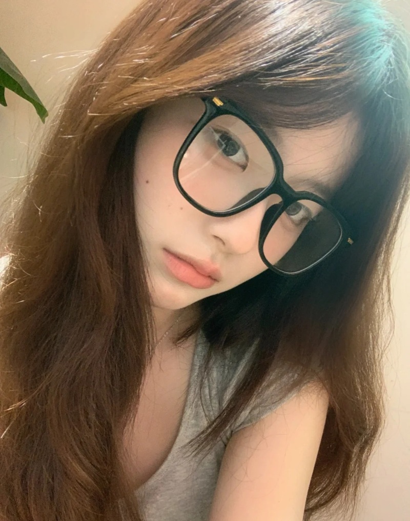 Cô gái đeo kính lớn và tạo dáng ngả đầu