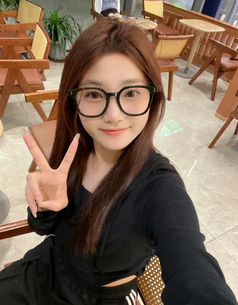 Cô gái đeo kính giơ tay ký hiệu chữ V