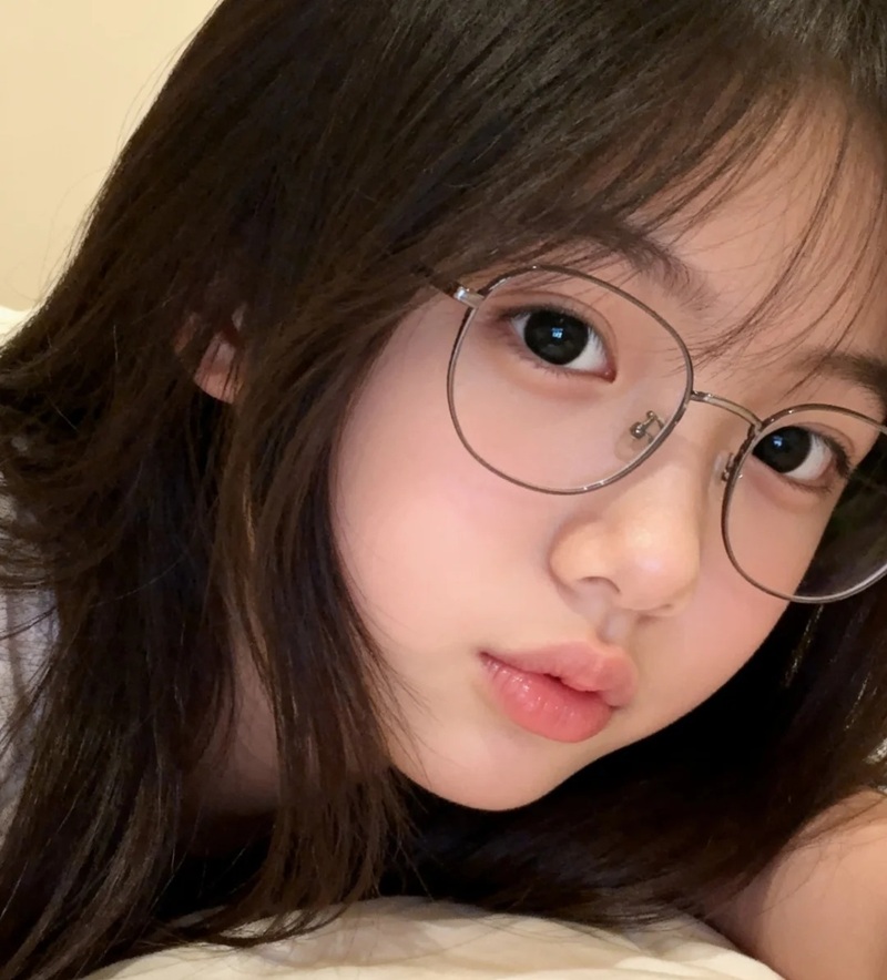Cô gái tóc dài cột nhẹ và kính tròn dễ thương