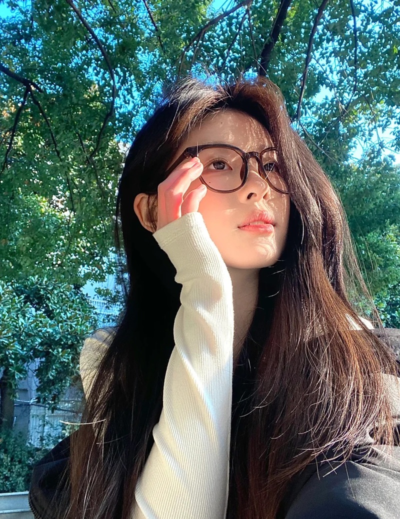 Cô gái che nắng bằng tay khi nhìn lên bầu trời