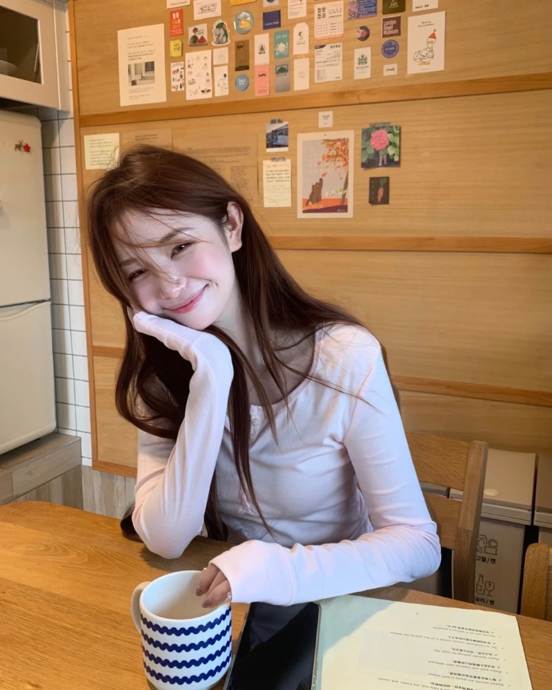 Cô gái Hàn Quốc ngồi trên bàn cười nhẹ