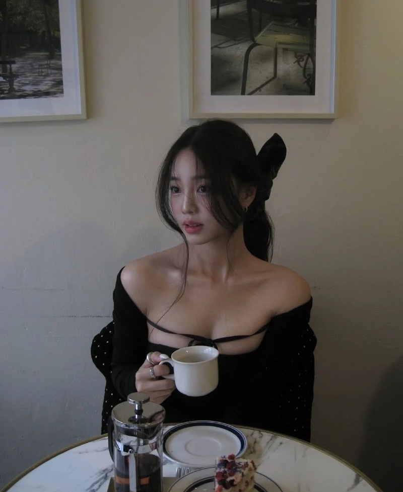 Cô gái Hàn Quốc ngồi trên ghế cạnh cốc cà phê