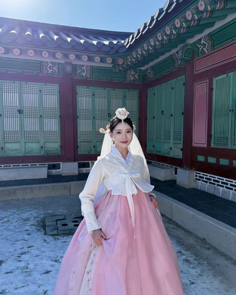 Cô gái Hàn Quốc mặc váy hồng tạo dáng bên tòa nhà