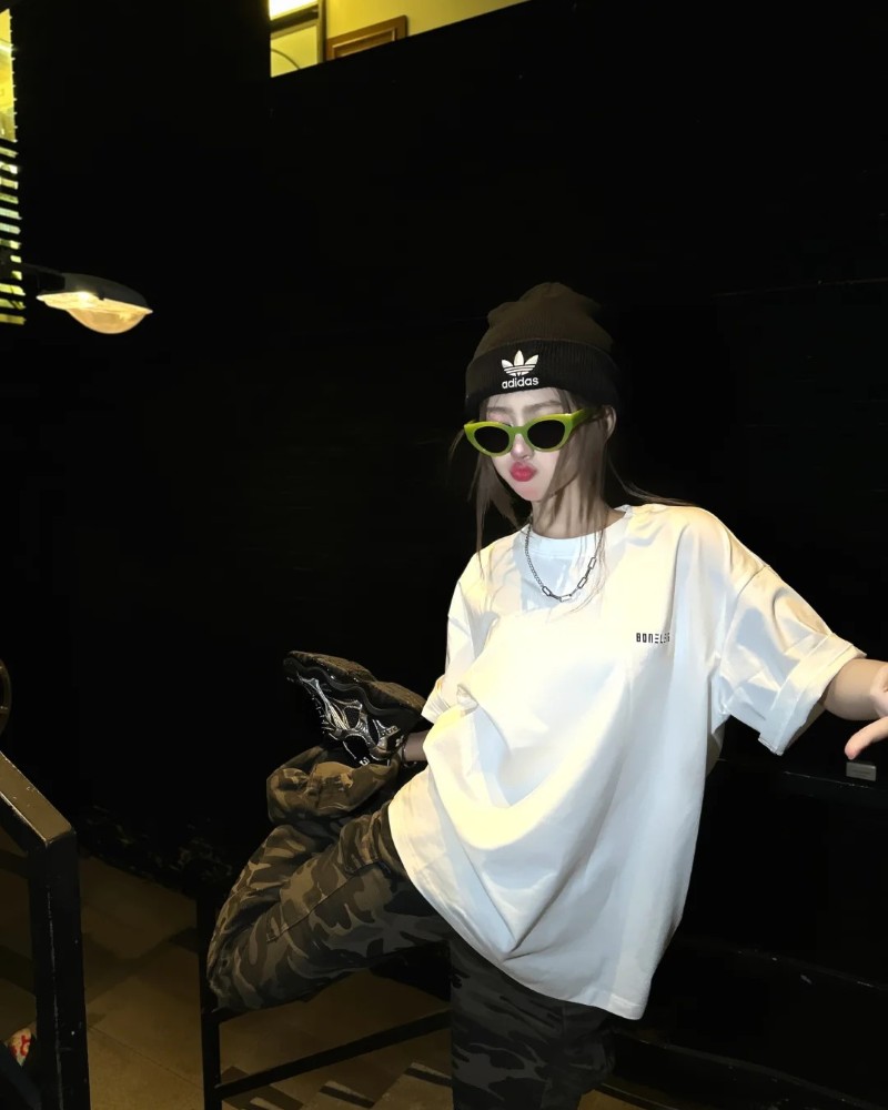 Cô gái đứng trước cửa kính với outfit đen