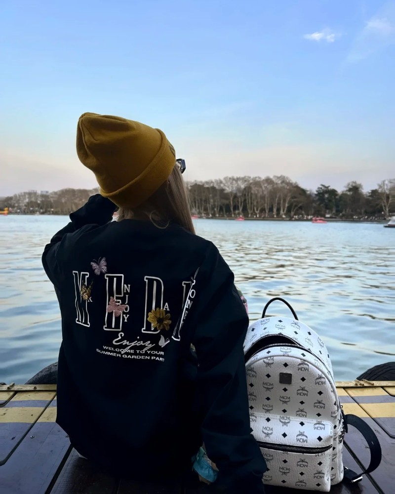 Cô gái mặc hoodie xanh đứng bên hồ