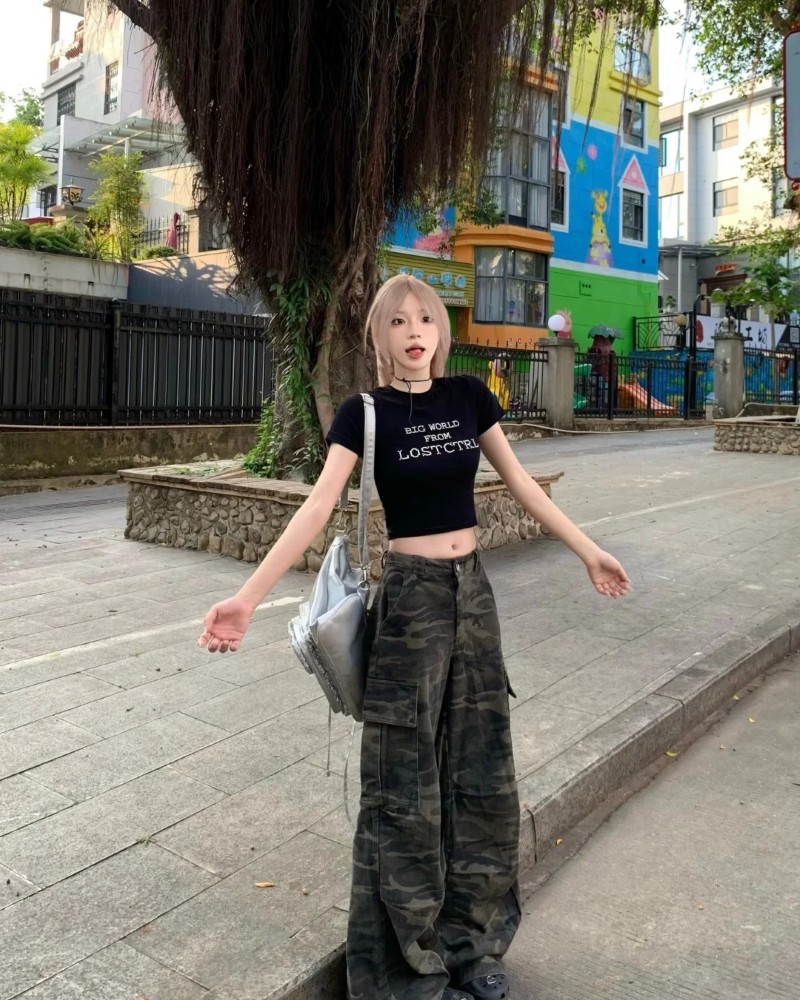Cô gái mặc áo đen và quần cargo tạo dáng ngầu