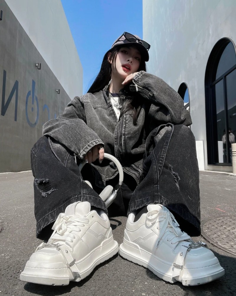 Cô gái ngồi bắt chéo chân với outfit đen trắng