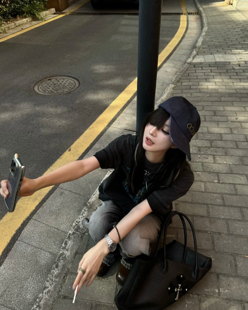 ảnh gái xinh ngầu ngồi dựa tường trong bộ đồ tối màu