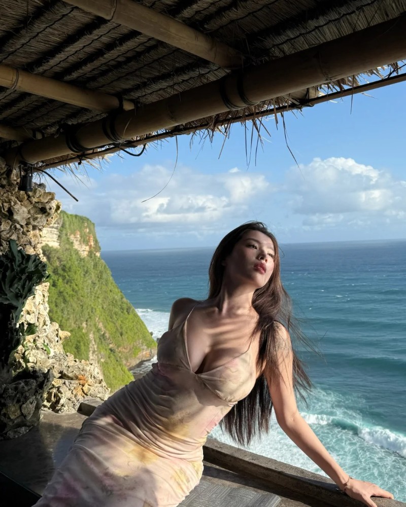 Cô gái ngồi trên đá gần bờ biển