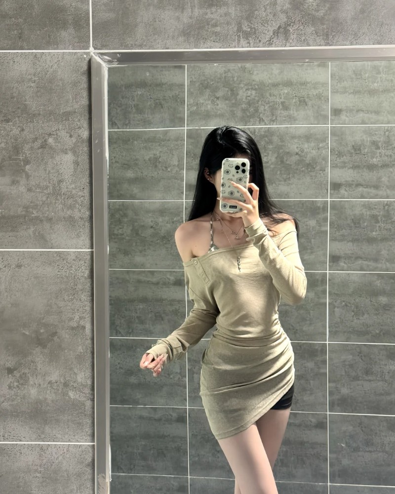 Cô gái diện váy vàng nhạt đứng trước tường xám