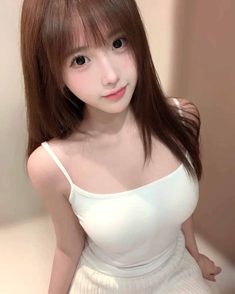 nàng mặc áo hai dây trắng, gương mặt xinh xắn