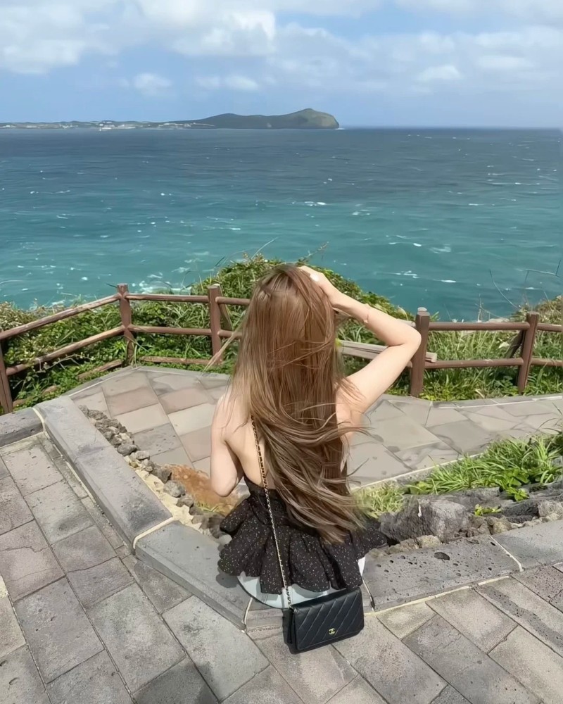 cô gái mặc váy tạo dáng nhìn về biển