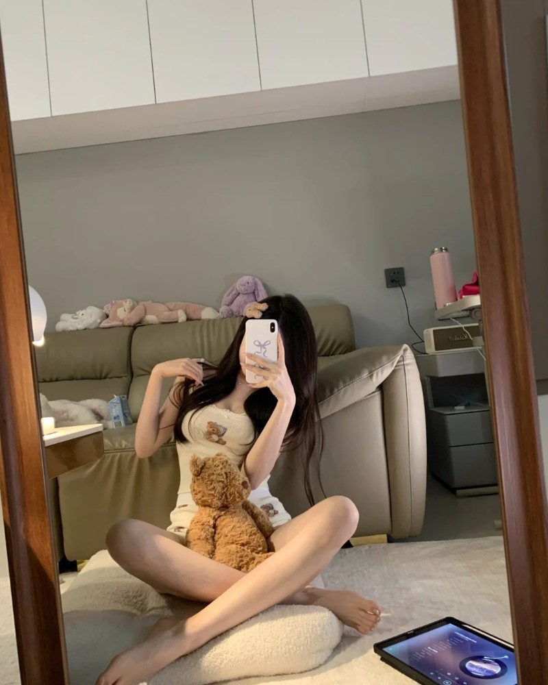 nàng selfie trong phòng khách với ánh sáng vàng