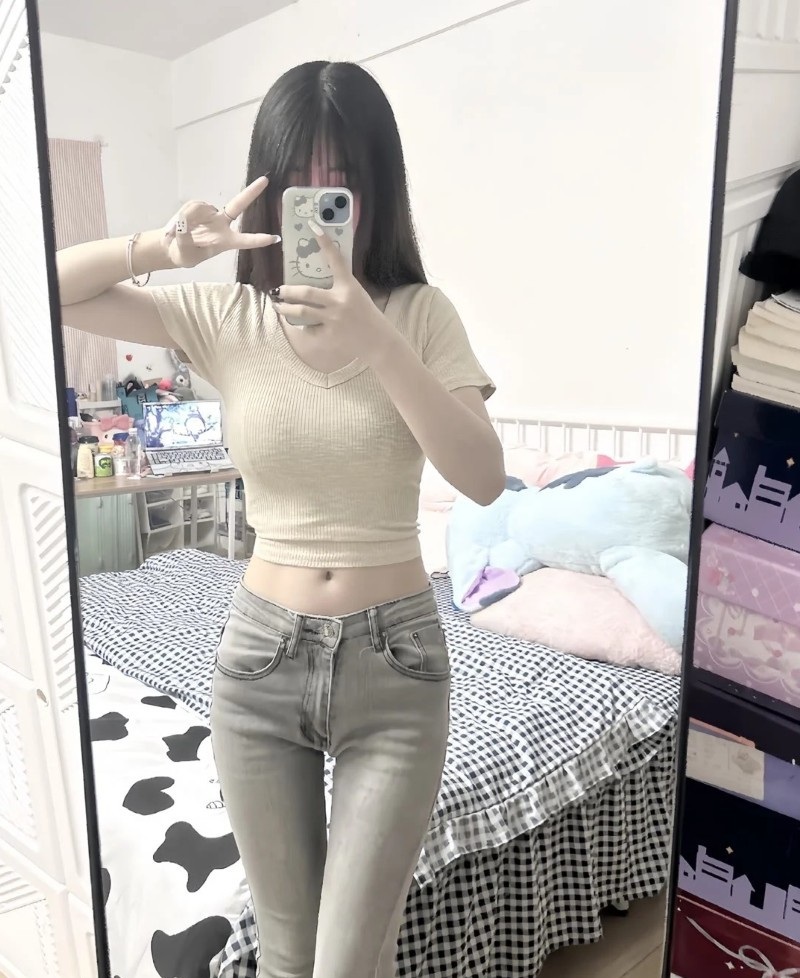 cô gái tạo dáng trước gương với áo trắng đơn giản