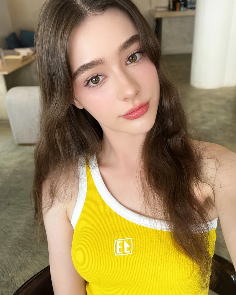 nàng mặc áo vàng ngồi tại quán, nụ cười rạng rỡ