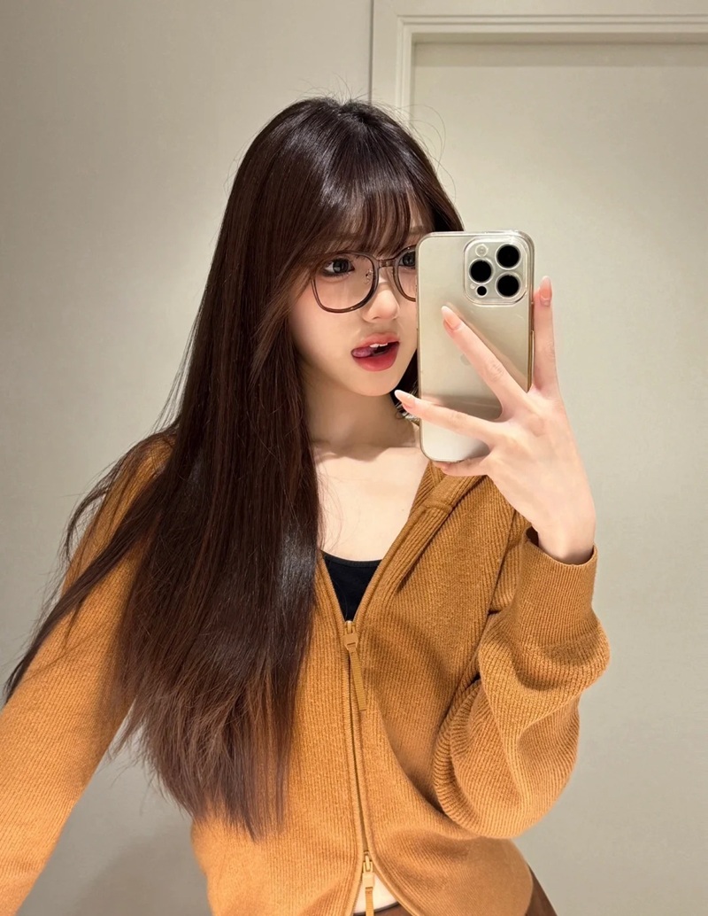 Cô gái tóc dài che một phần khuôn mặt với kính gọng nhỏ