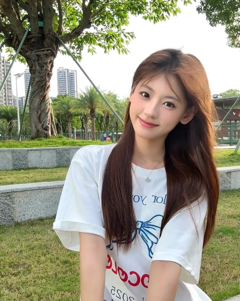 Cô gái mặc áo trắng tạo dáng cạnh hàng ghế đá