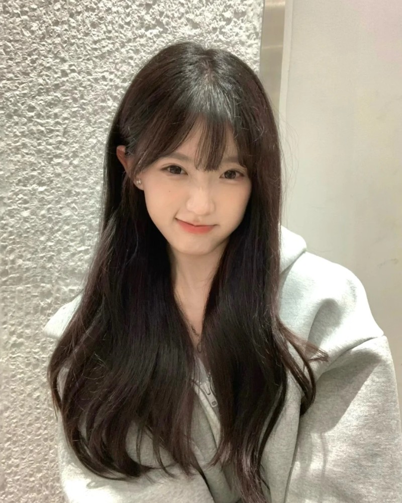 Cô gái tóc dài thẳng chụp ảnh trong phòng đơn giản