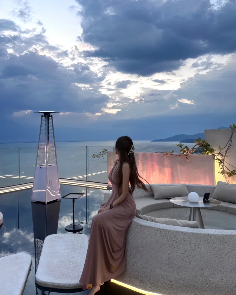 Cô gái ngồi du lịch ven biển trong trang phục nhẹ