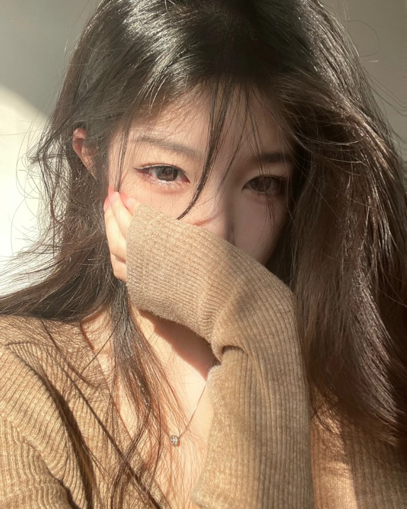 Cô gái che mặt bằng tay với ánh sáng vàng ấm