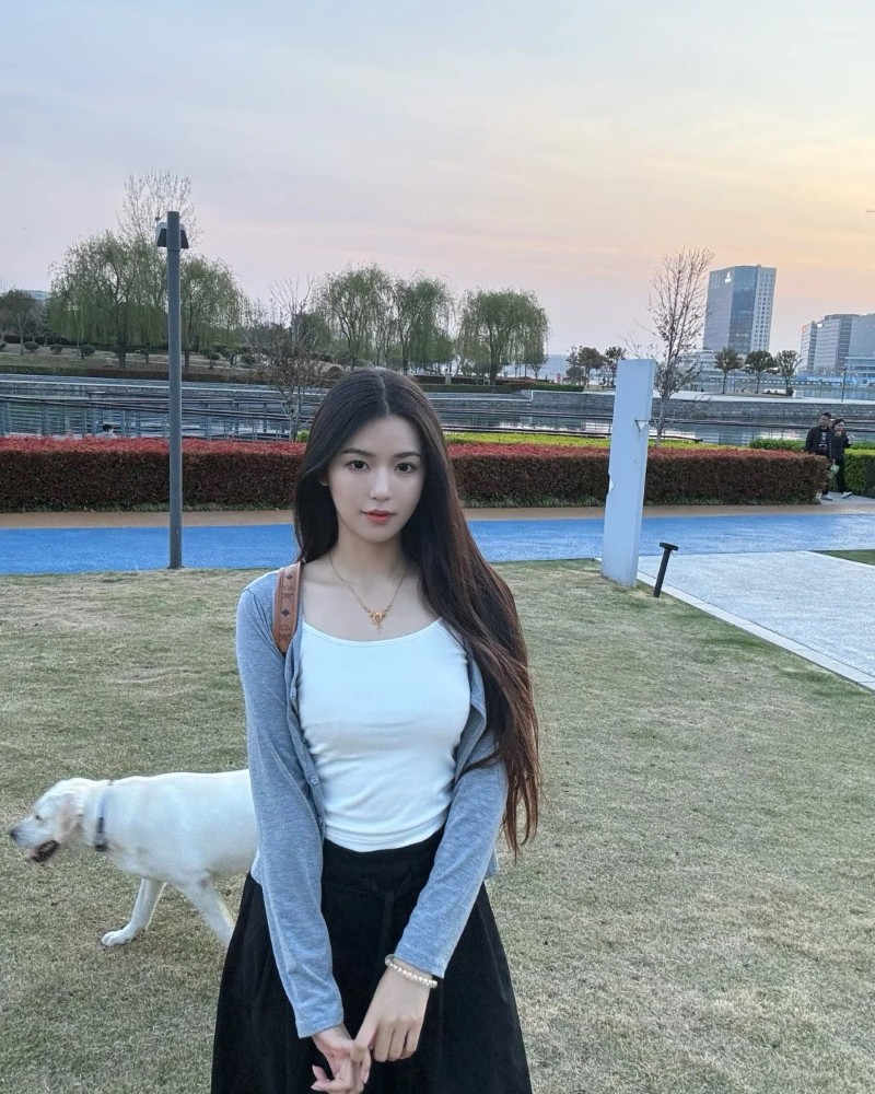 Cô gái ngồi trên ghế trong công viên chụp ảnh