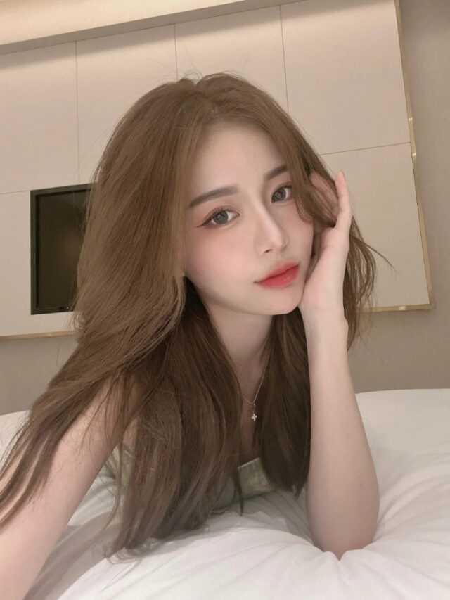 cô gái tóc nâu dài tạo dáng trong phòng