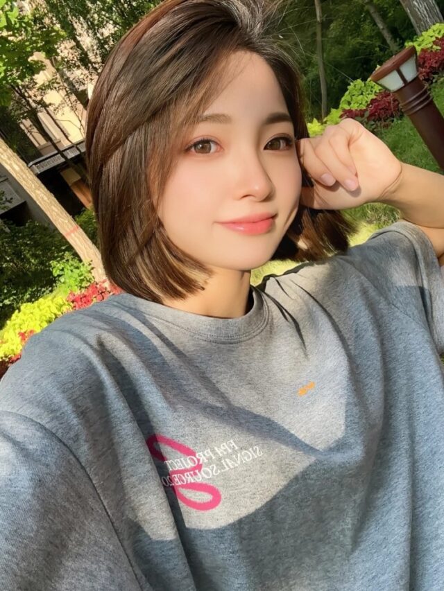 bạn nữ tóc ngắn cười tươi dưới tán cây