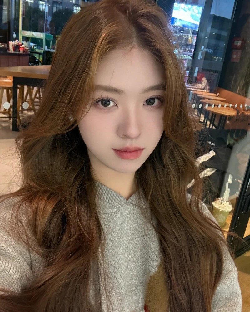 bạn nữ tóc xoăn nhẹ đứng ngoài ban công