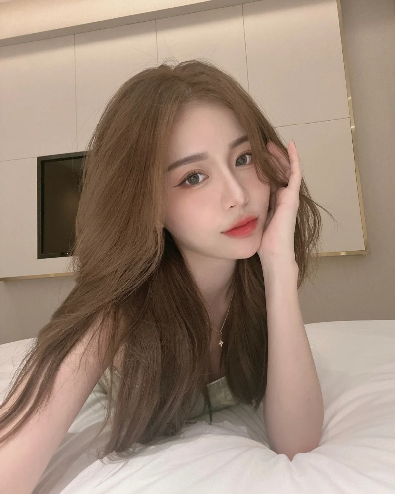 cô gái tóc nâu dài tạo dáng trong phòng