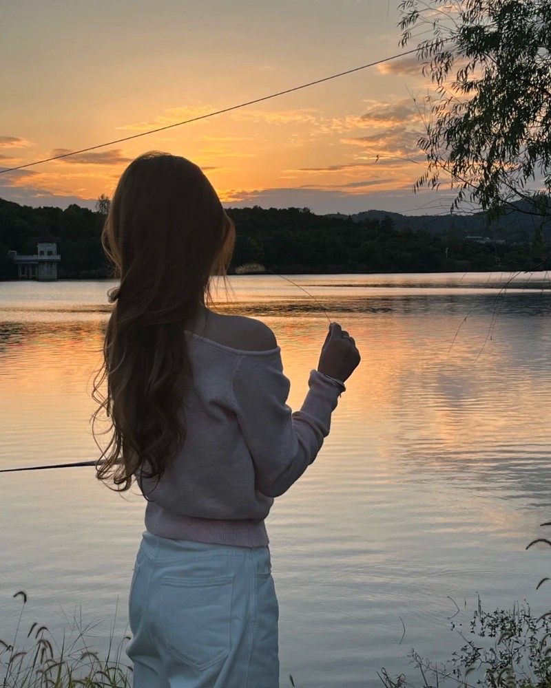 cô gái nhìn hoàng hôn bên hồ nước