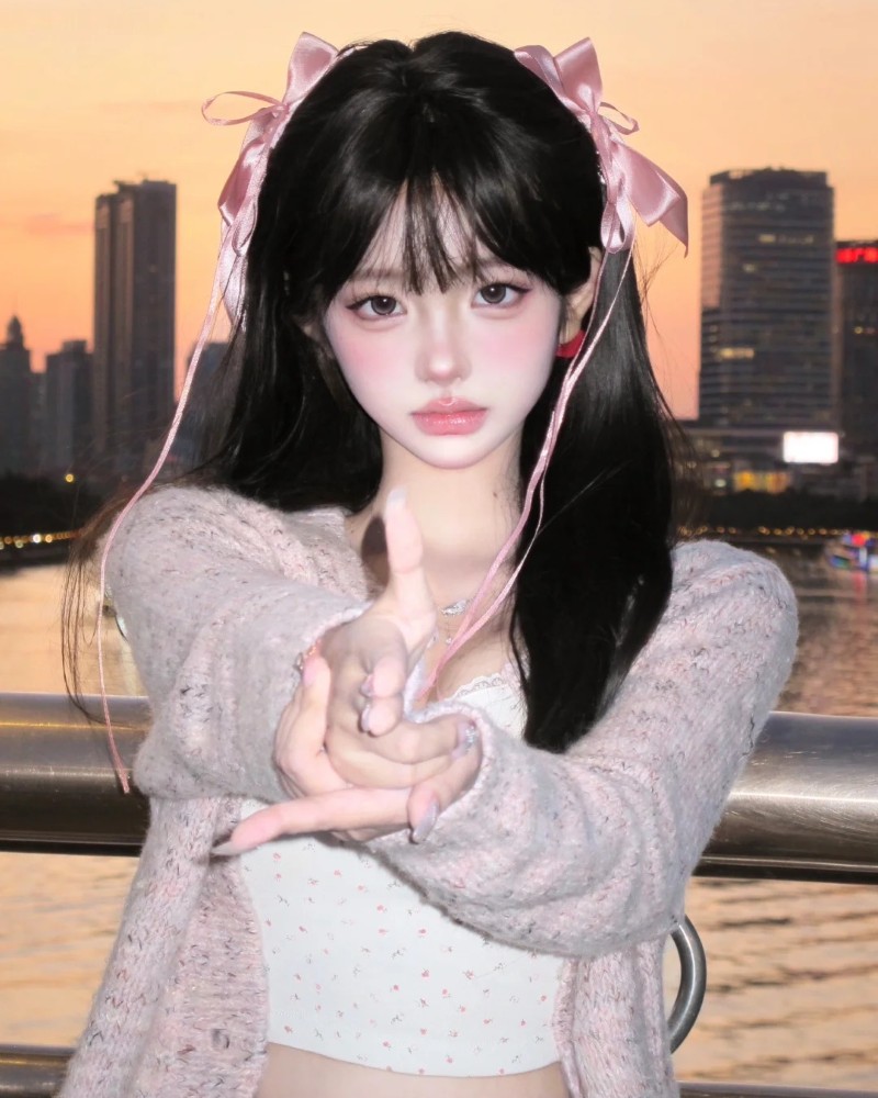 cô gái tạo dáng với áo len hồng