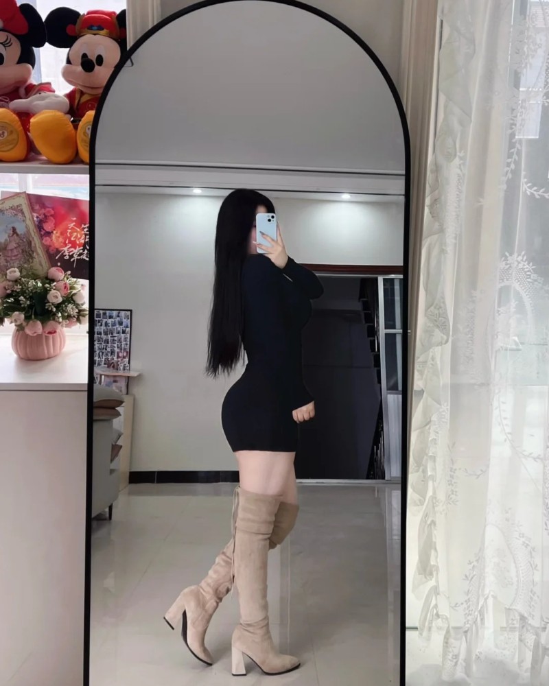 Cô gái tạo dáng trước gương trong trang phục thanh lịch