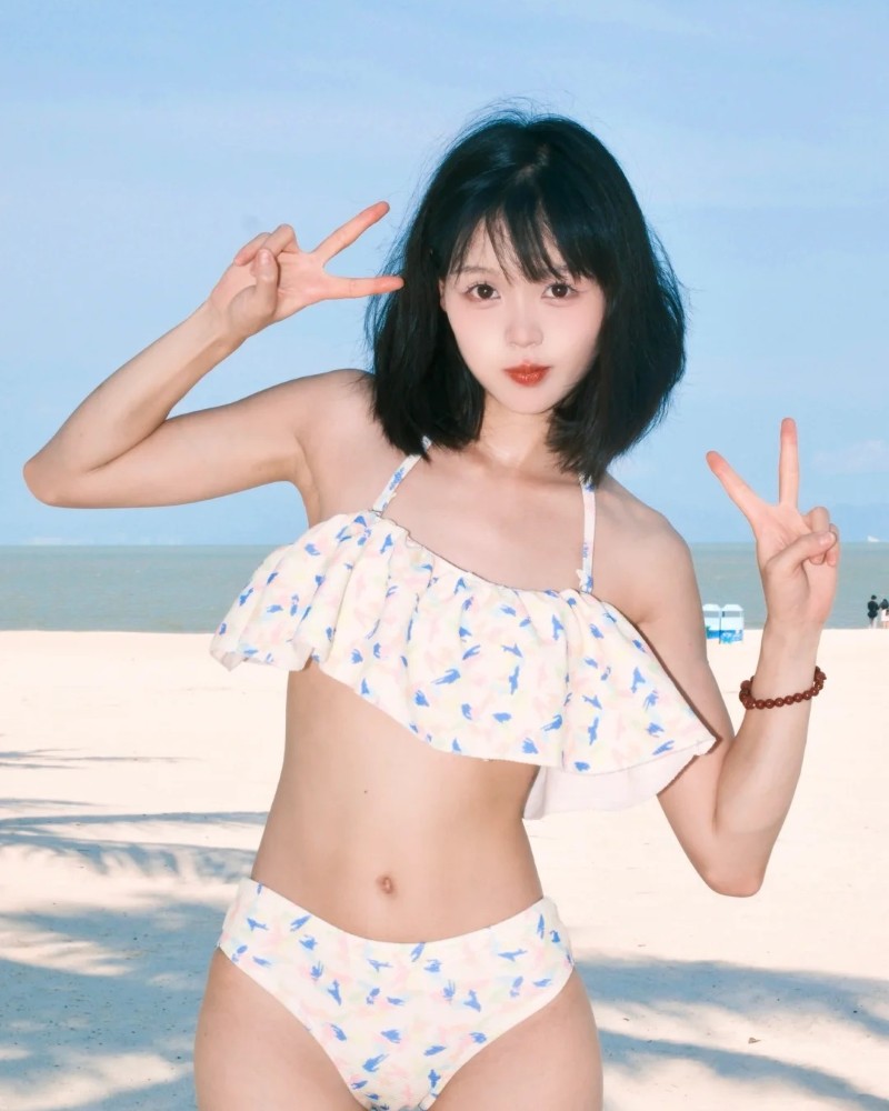 Người đẹp mặc bikini tạo dáng gần cây xanh