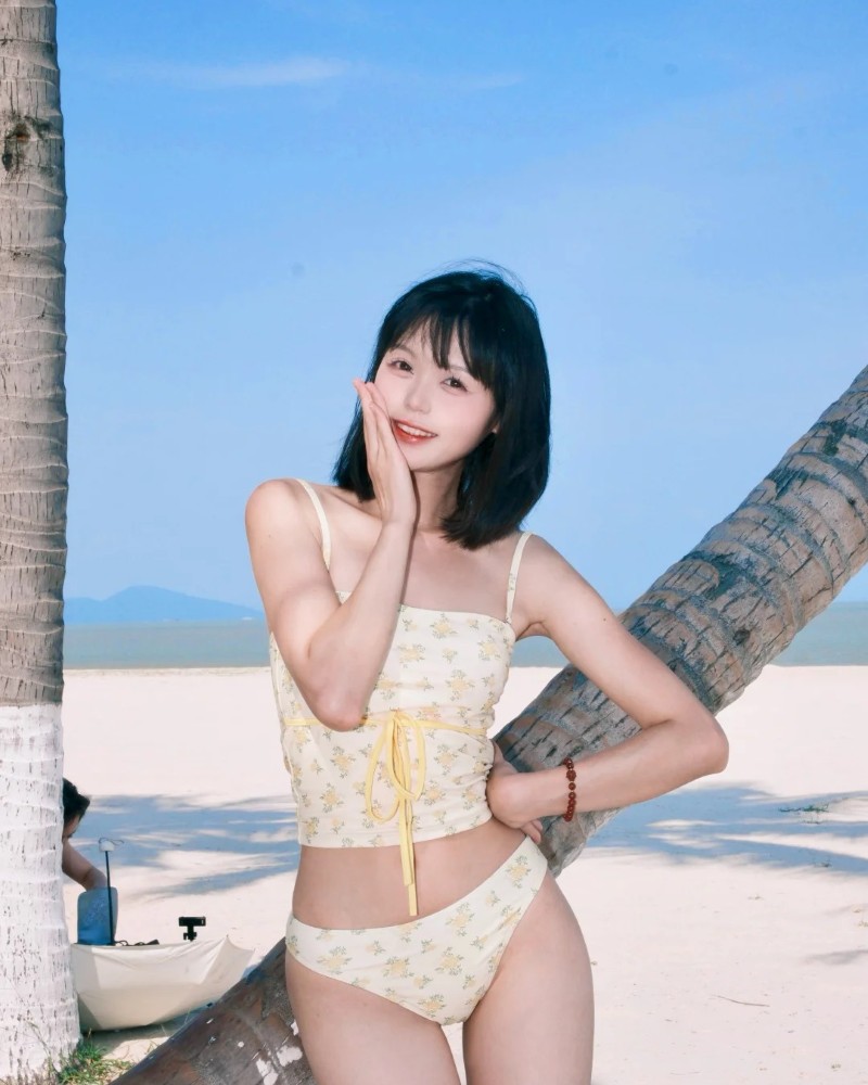 Người đẹp mặc bikini tạo dáng trước cây dừa