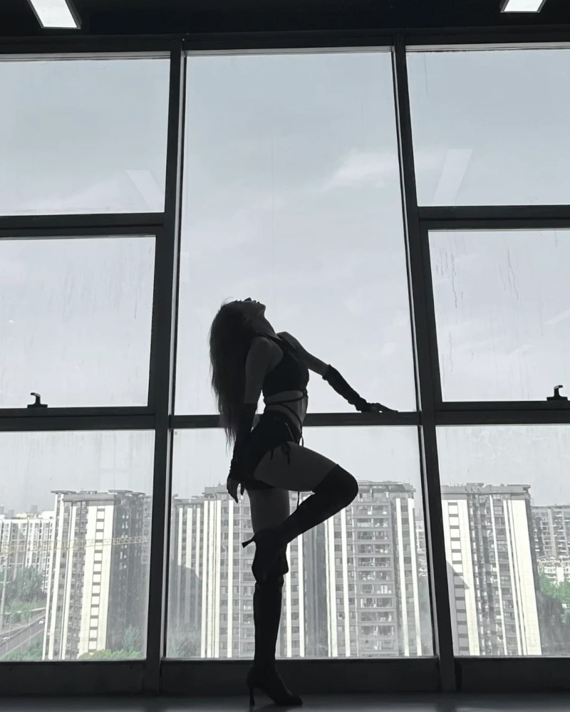 Nữ vũ công biểu diễn trước cửa kính lớn