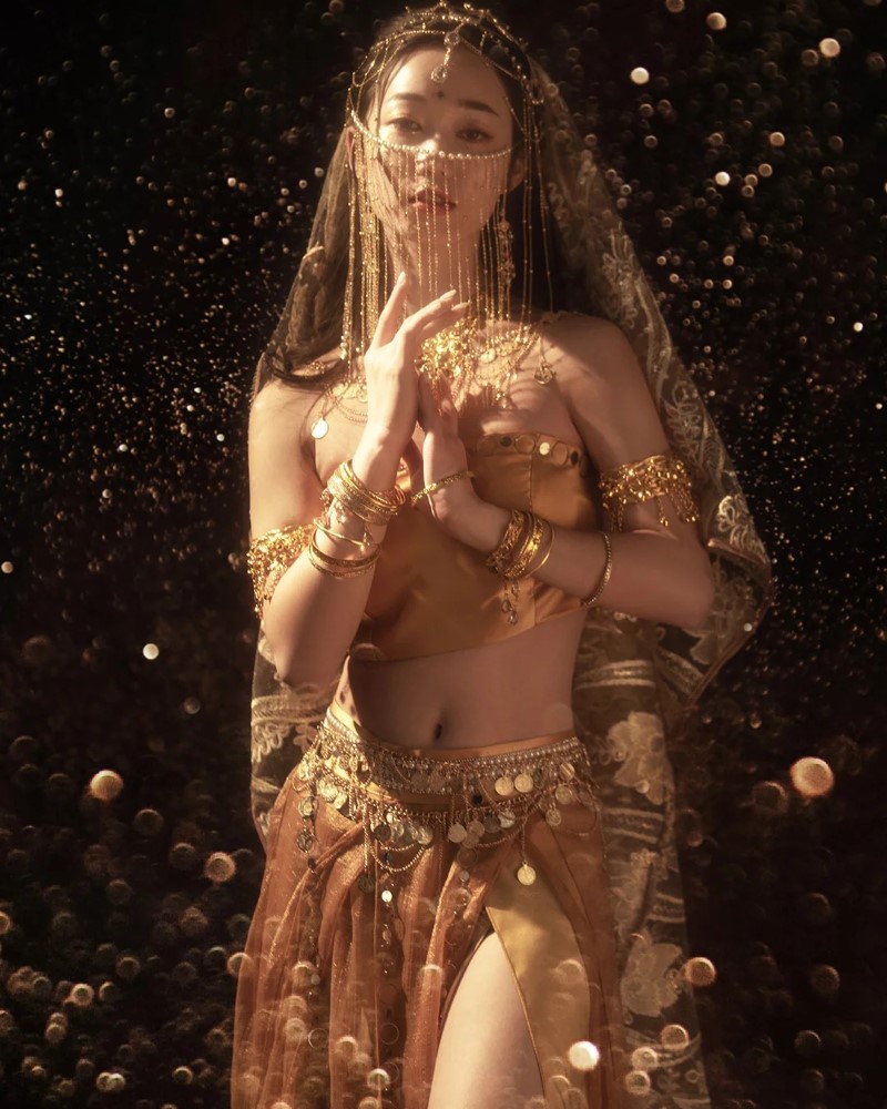 Nữ vũ công nhảy với background ánh sáng vàng