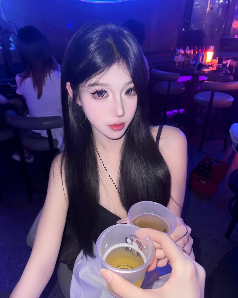 Nàng cầm ly đồ uống tạo dáng trước camera