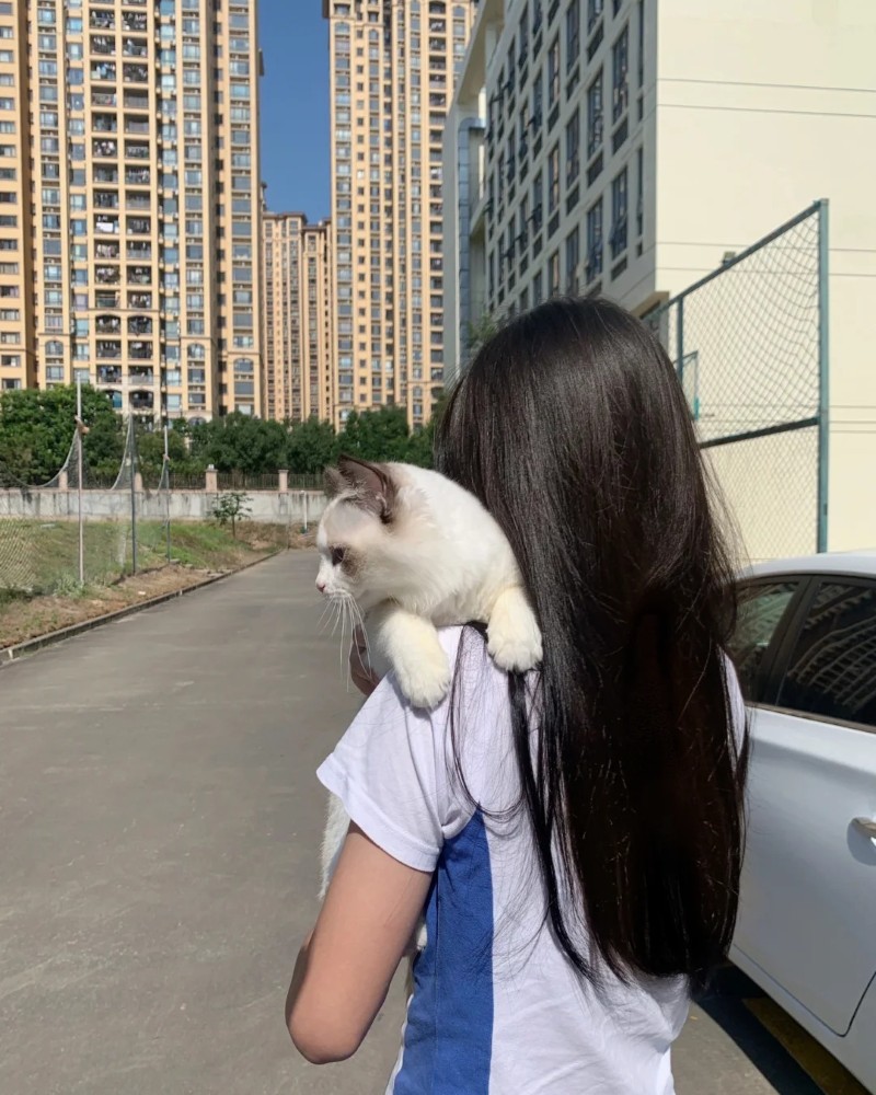 Nữ sinh đứng cạnh tòa nhà