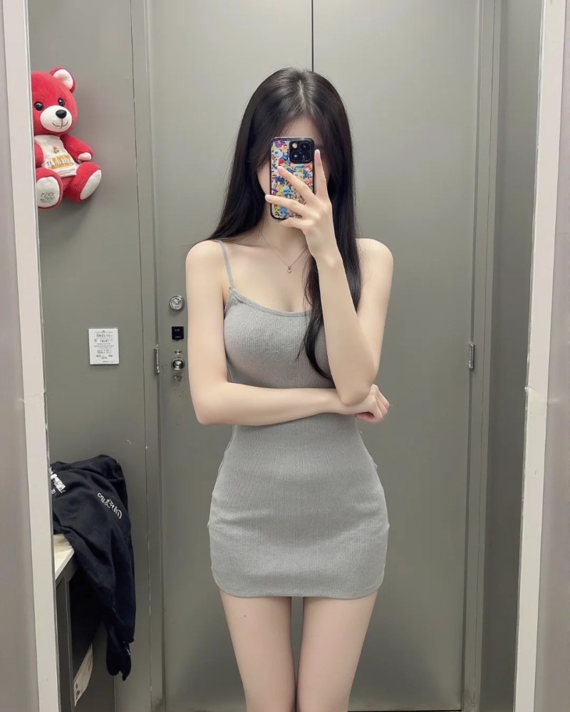 Cô nàng đứng trước gương trong váy ngắn tôn dáng