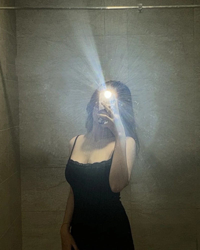 Người đẹp chụp ảnh trong phòng tối với ánh đèn phản chiếu