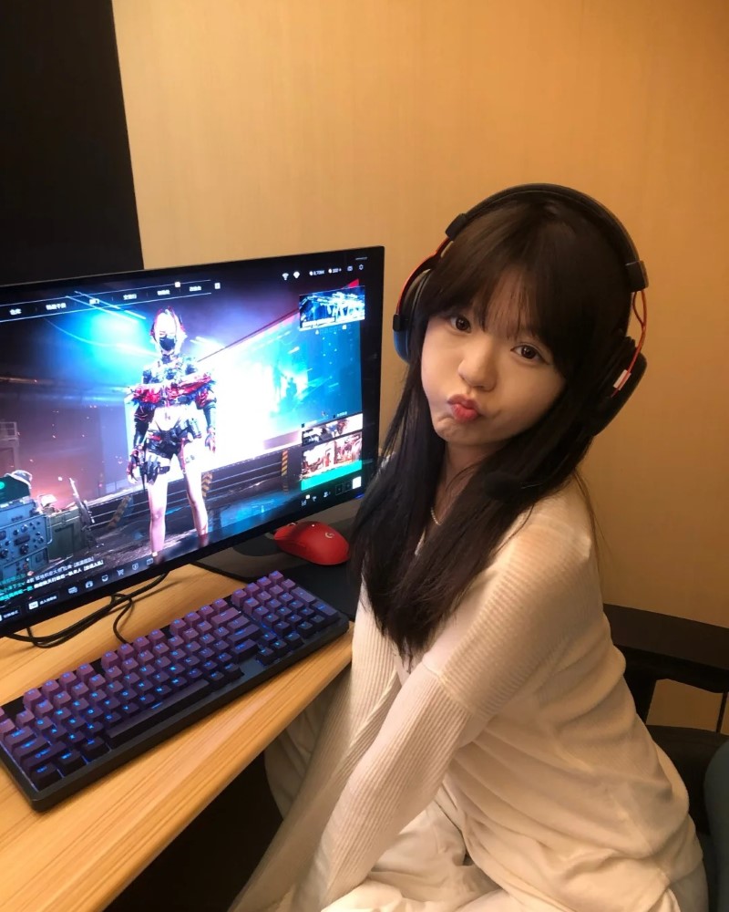 Nữ streamer ngồi cạnh màn hình máy tính