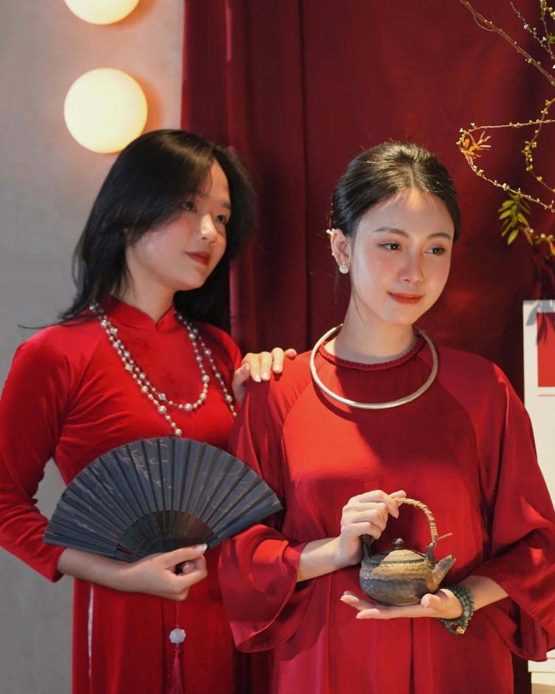 Hai cô gái mặc áo dài đỏ tạo dáng truyền thống